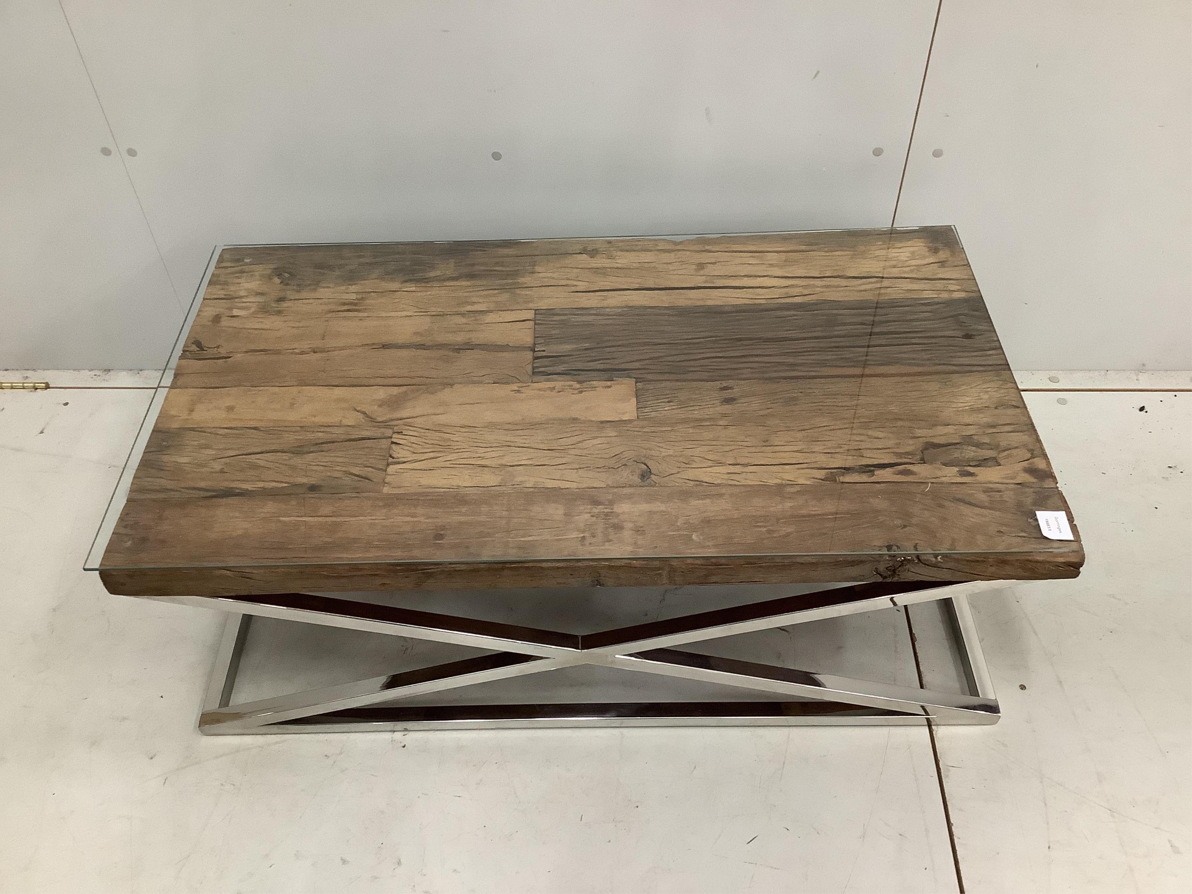 A Contemporary glass top weathered timber and chrome underframe coffee table, made from old train rail track woods, width 112cm, depth 61cm, height 40cm. Condition - good